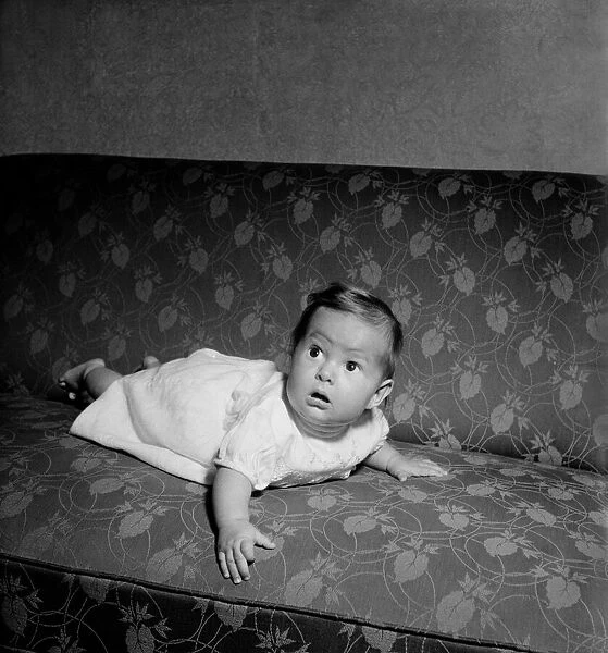Baby crawling on the sofa at his home. August 1952 C3999
