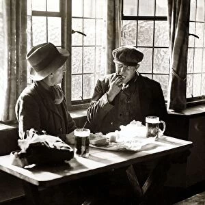 A couple of men having their lunch with a pint of beer in a public house