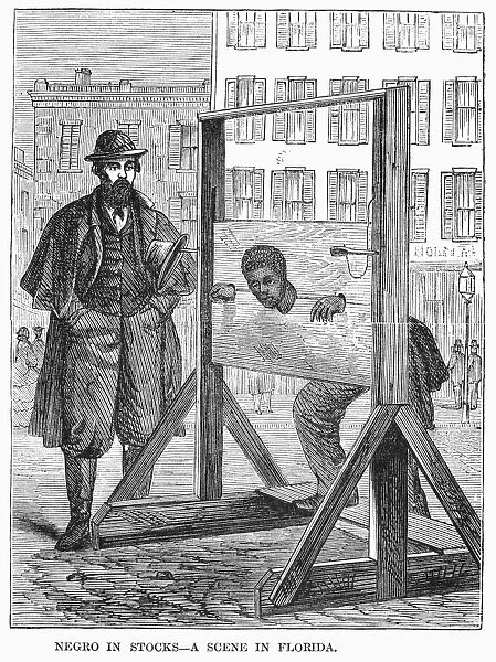 FLORIDA: STOCKS, 1866. A black man is punished with public humiliation in the stocks at a town in Florida. Wood engraving, American, 1866
